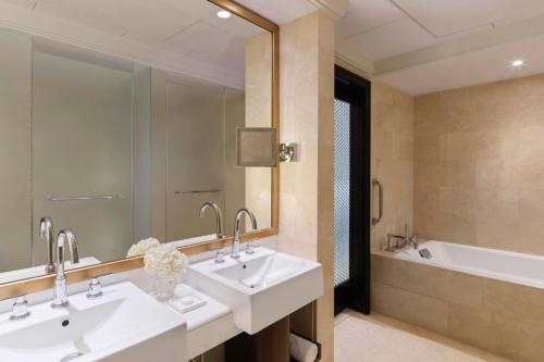 a bathroom with two sinks and a bath tub at The Ritz-Carlton Abu Dhabi, Grand Canal in Abu Dhabi