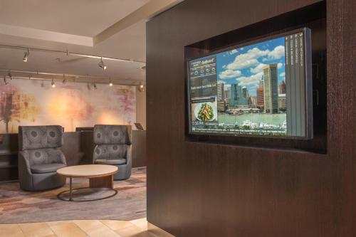 a waiting room with two chairs and a flat screen tv at Courtyard By Marriott Baltimore BWI Airport in Linthicum Heights