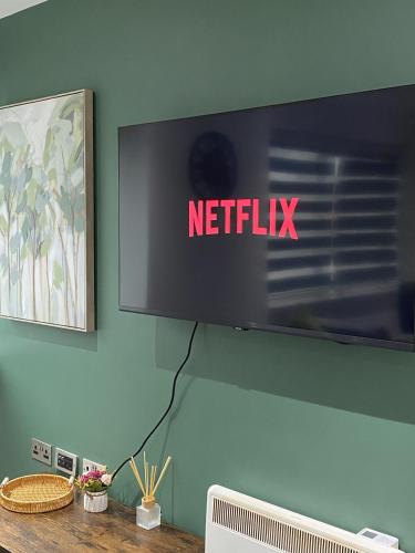 a television on a wall with the netflix sign on it at Sweet Stay, 2 Bed Luxury Apartment close to Birmingham Central in Birmingham