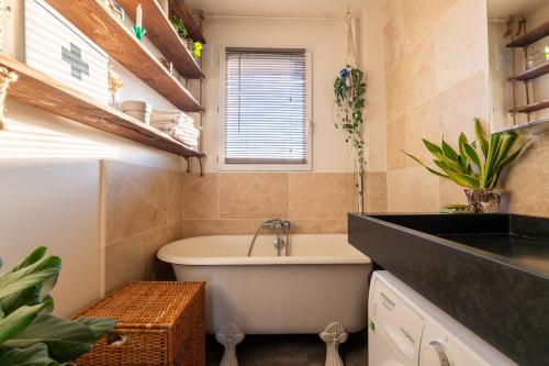 une salle de bain avec une baignoire et un lavabo dans l'établissement Cozy escape in a refined 2 room - Paris 14e, à Paris