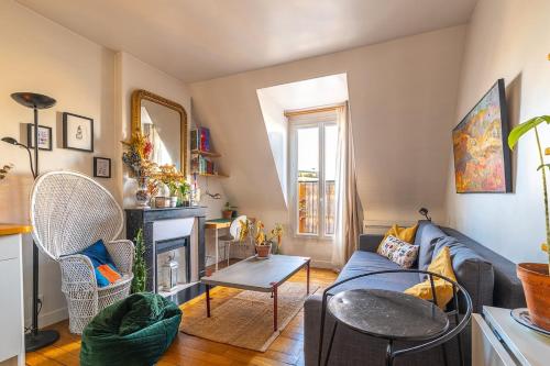 un salon avec un canapé et une cheminée dans l'établissement Cozy escape in a refined 2 room - Paris 14e, à Paris