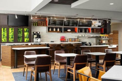 a bar with tables and chairs in a restaurant at Courtyard Birmingham Hoover in Hoover