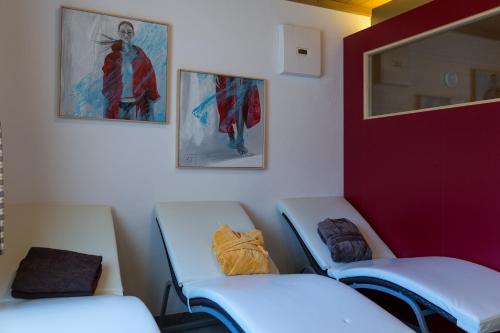 a room with two empty chairs and paintings on the wall at Hotel Bergland in Sillian