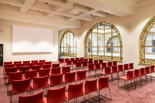 an empty lecture hall with red chairs and a whiteboard at The Marmorosch Bucharest, Autograph Collection in Bucharest