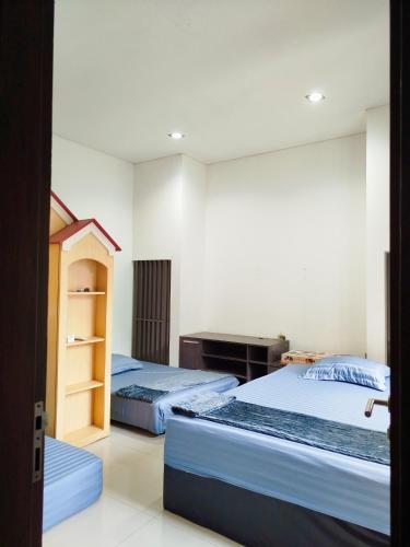 a bedroom with two beds and a desk at Cheery Room 203 in Surabaya