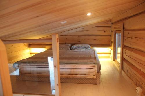 ein Schlafzimmer in einem Blockhaus mit einem Bett darin in der Unterkunft Syöte Cottage in Syöte
