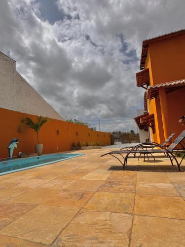 a patio with two chairs next to a building at Pousada du Vento in Cruz