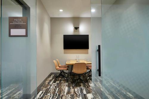 a conference room with a table and a tv on a wall at AC Hotel by Marriott Austin Hill Country in Austin