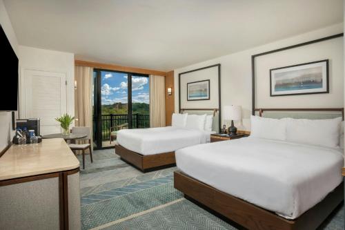 a hotel room with two beds and a balcony at Merriweather Lakehouse Hotel, Autograph Collection in Columbia