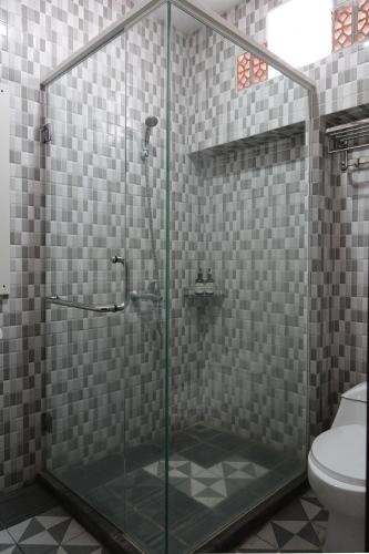 a bathroom with a glass shower with a toilet at Baratha Hotel & Resto in Bondowoso