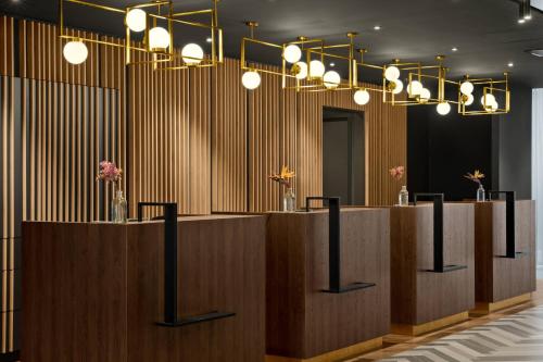 a row of reception desks in a room with lights at Renaissance Amsterdam Schiphol Airport Hotel in Schiphol
