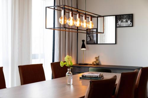 a dining room with a table and a chandelier at Renaissance Amsterdam Schiphol Airport Hotel in Schiphol