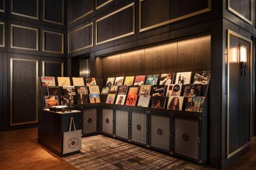 a display case in a room with photos on the wall at The Otis Hotel Austin, Autograph Collection in Austin