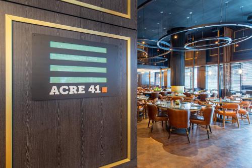 a restaurant with tables and chairs and a sign on the wall at The Otis Hotel Austin, Autograph Collection in Austin