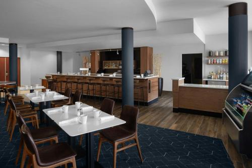 Courtyard Los Angeles Burbank Airport في بربانك: مطعم به طاولات وكراسي وبار