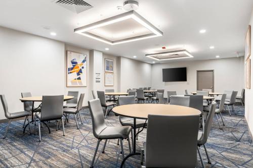a conference room with tables and chairs and a screen at Holiday Inn Express Van Nuys by IHG in Van Nuys