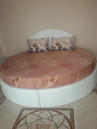 a round bed with pink sheets and pillows in a room at Sandanski Peak Guest Rooms in Sandanski