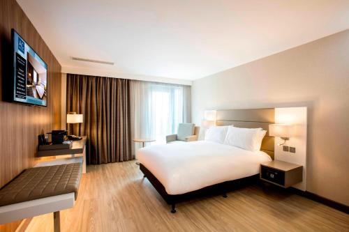 a hotel room with a large bed and a desk at AC Hotel by Marriott Birmingham in Birmingham