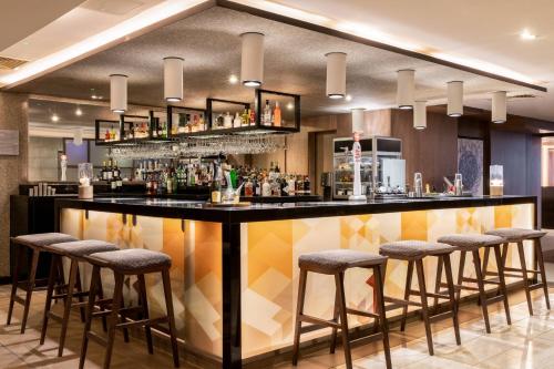 a bar in a hotel room with stools at AC Hotel by Marriott Birmingham in Birmingham
