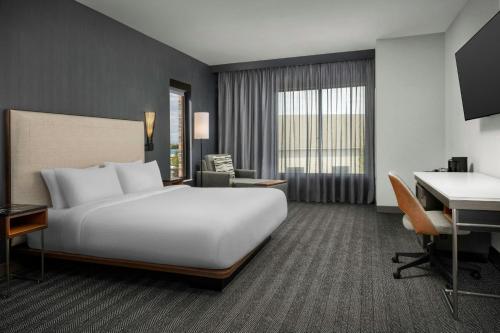 a hotel room with a large white bed and a desk at Courtyard by Marriott Bozeman in Bozeman