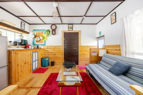 a living room with a couch and a table at Family house プール付オーシャンビュー Amami "Birdland Nature Resort" in Amami