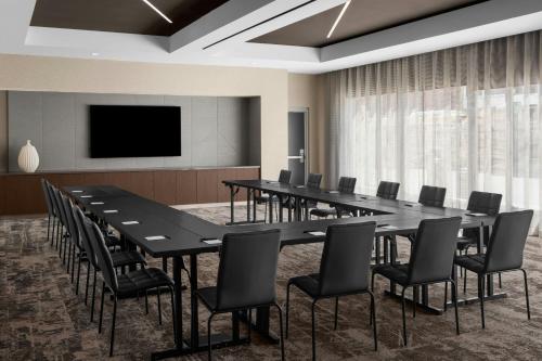 a conference room with a large black table and chairs at AC Hotel by Marriott Bozeman Downtown in Bozeman