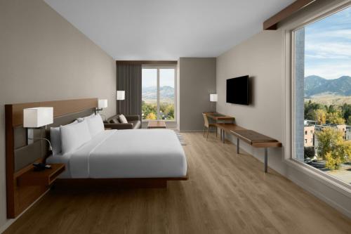 a hotel room with a bed and a large window at AC Hotel by Marriott Bozeman Downtown in Bozeman