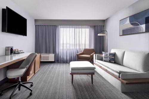 a living room with a couch and a desk in a hotel room at Courtyard Austin South in Austin