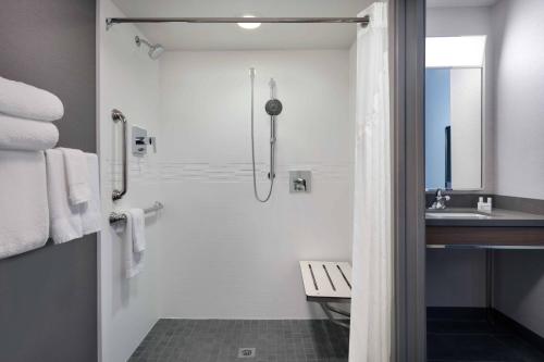 a white bathroom with a shower and a sink at Courtyard Austin South in Austin