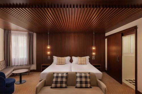 a hotel room with a bed and a couch at Hotel Ercilla de Bilbao, Autograph Collection in Bilbao