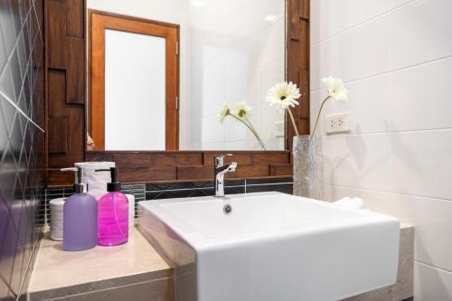 a bathroom with a white sink and a mirror at Laguna Beach Villa Phuket 207byน้องมังคุด in Ban Pak Lak