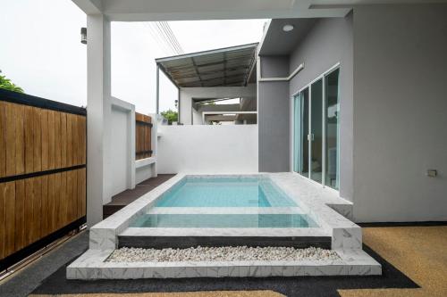 a swimming pool in the middle of a house at Laguna Beach Villa Phuket 207byน้องมังคุด in Ban Pak Lak