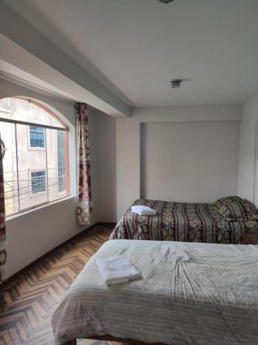 ein Schlafzimmer mit einem Bett und einem Fenster in der Unterkunft Habitación cómoda y confortable en el corazón de Puno in Puno