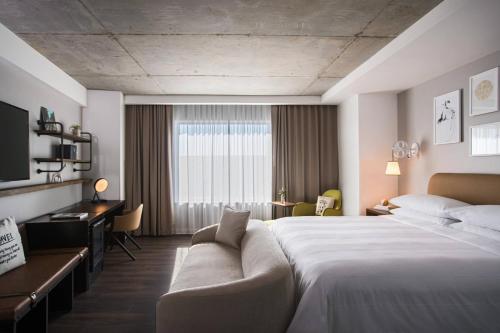 a hotel room with a large bed and a couch at Renaissance Atlanta Airport Gateway Hotel in Atlanta
