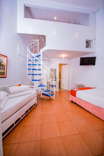 a bedroom with two beds and a spiral staircase at Paras Beach Resort - Camiguin in Mambajao