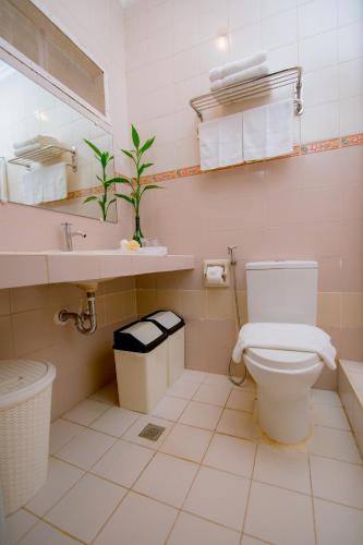 a bathroom with a toilet and a sink at Paras Beach Resort - Camiguin in Mambajao