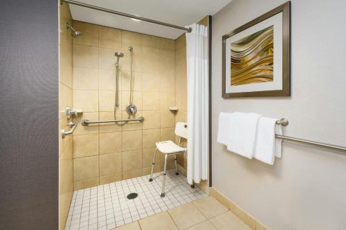 a bathroom with a shower and a toilet at Courtyard Hartford Farmington in Farmington