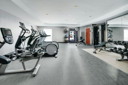 a gym with treadmills and elliptical machines at Courtyard Hartford Farmington in Farmington