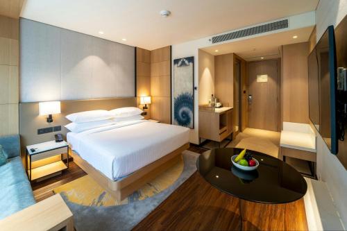 巴罗达Courtyard by Marriott Vadodara的带一张大床和一张桌子的卧室