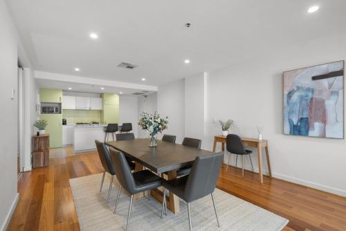 a dining room with a table and chairs at Belle Escapes - Lazy Days on Colley Terrace in Glenelg