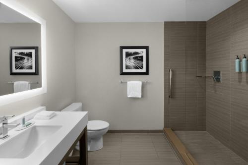 a bathroom with a sink and a toilet and a shower at Courtyard by Marriott Akron Downtown in Akron