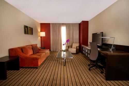 a living room with a couch and a desk with a computer at Renaissance Caracas La Castellana Hotel in Caracas