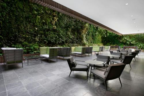 a restaurant with tables and chairs and a green wall at Renaissance Caracas La Castellana Hotel in Caracas
