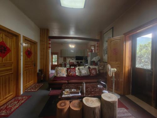 a living room with a couch and wooden logs at Xin'anjiang Landscape Gallery Ran Yuezhu Bed and Breakfast in She