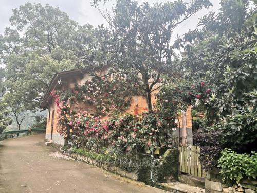 a house with flowers on the side of it at Xin'anjiang Landscape Gallery Ran Yuezhu Bed and Breakfast in She
