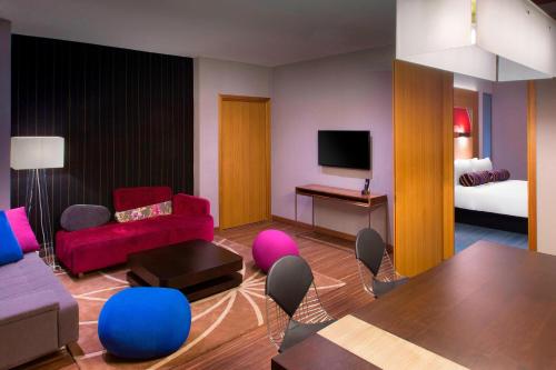 a living room with a couch and a bed at Aloft Bengaluru Outer Ring Road in Bengaluru