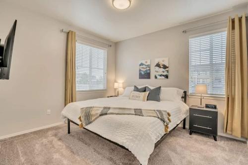a bedroom with a large bed and two windows at Luxury King Beds Pool Gym - Near Hill AFB in Clearfield