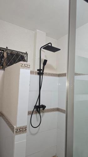a shower with a black shower head on a wall at Azure in Georgetown