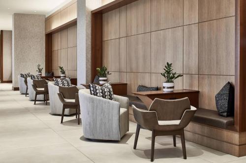 a row of chairs and tables in a hotel lobby at AC Hotel by Marriott Atlanta Airport Gateway in Atlanta