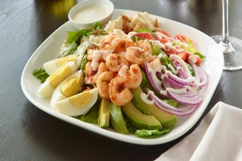 a plate of food with shrimp and vegetables on a table at AC Hotel by Marriott Atlanta Airport Gateway in Atlanta